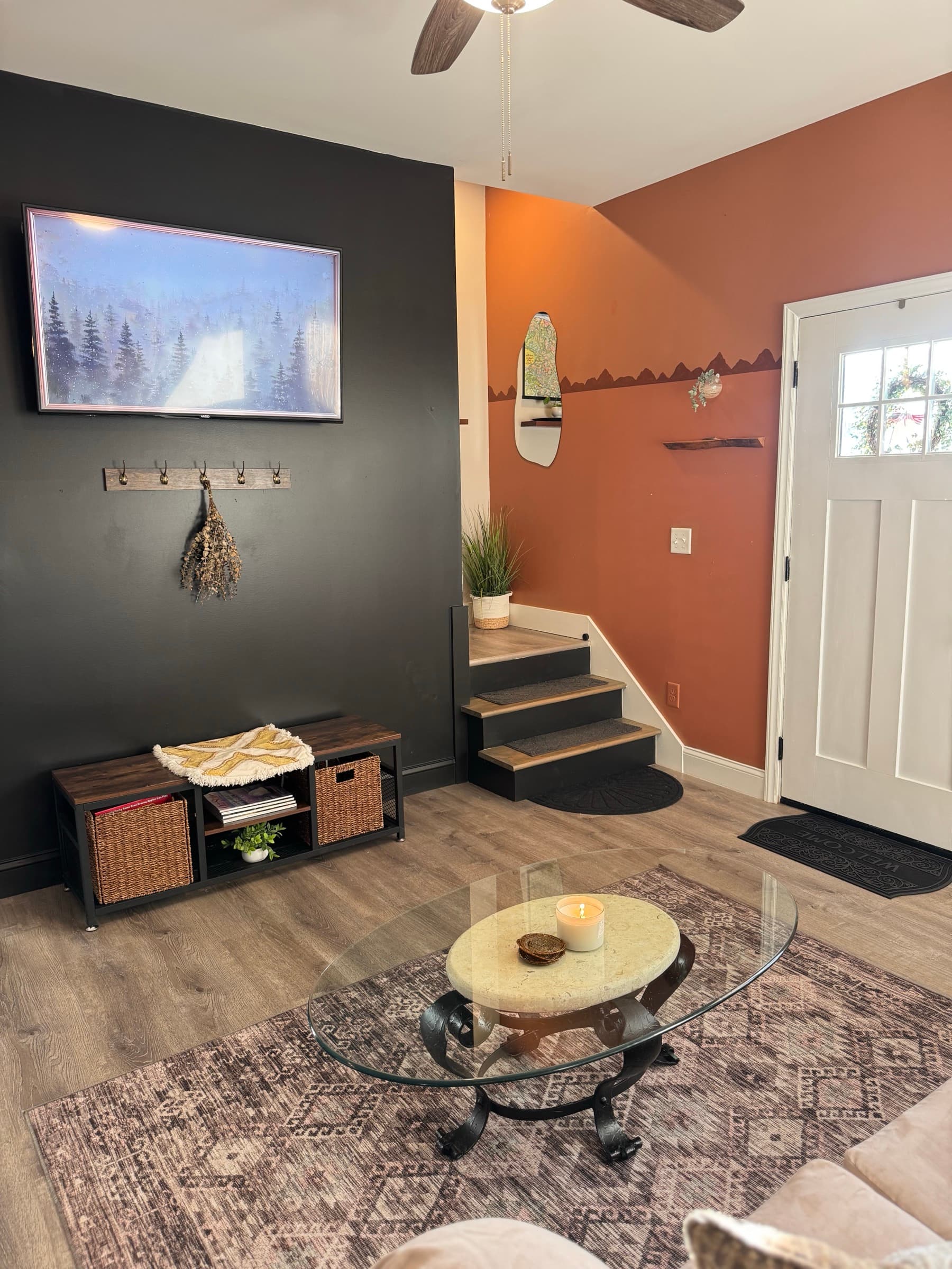 Living entry with TV wall, coffee table, and stairs to upper level